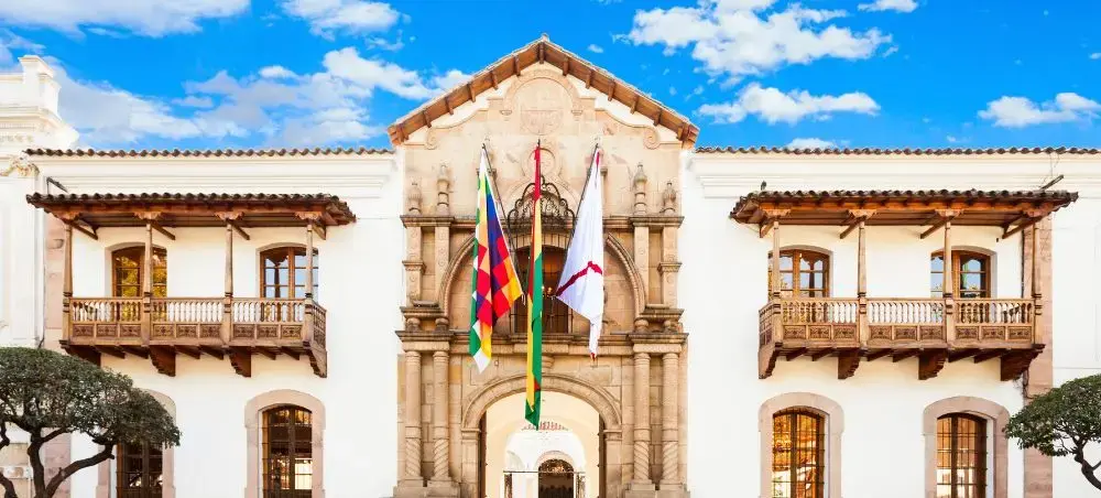 Historic colonial government building with ornate baroque facade and flags in Sucre, Bolivia's capital