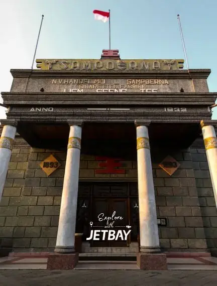 Historic Surabaya monument with classical columns and Indonesian flag showcasing the city's colonial heritage