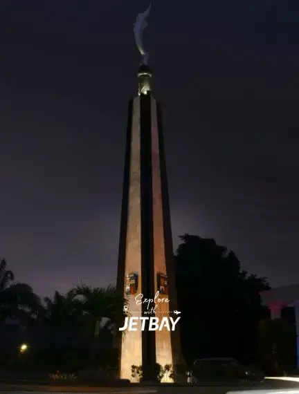 Illuminated Surabaya Heroes Monument towering against twilight sky with Jetbay branding overlay