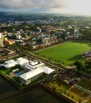 Aerial view of Suva cityscape with green sports field and modern buildings in Fiji's capital