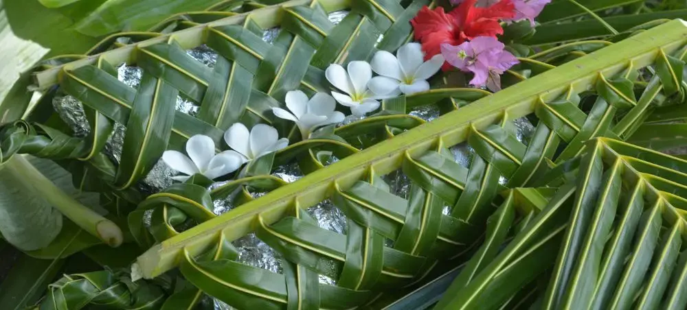 Traditional Fijian palm leaf weaving with white frangipani and hibiscus flowers showcasing Suva's cultural heritage