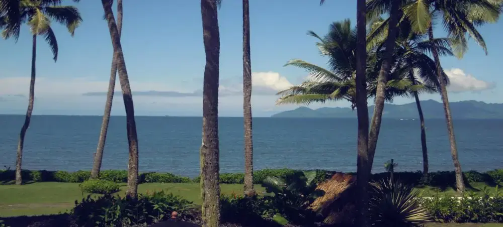 Tropical paradise view from Suva resort showing palm trees, pristine ocean waters, and distant mountains