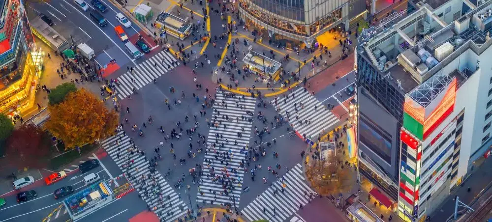 Aerial view of Tokyo's famous Shibuya crossing with pedestrians navigating multiple zebra crossings