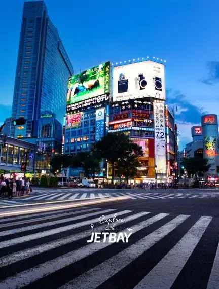 Bustling Shibuya crossing at dusk with illuminated billboards and skyscrapers in Tokyo's vibrant cityscape