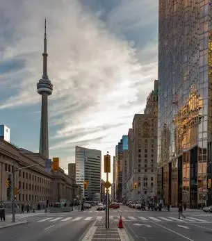 CN Tower dominates Toronto's downtown skyline with modern skyscrapers and urban streets below