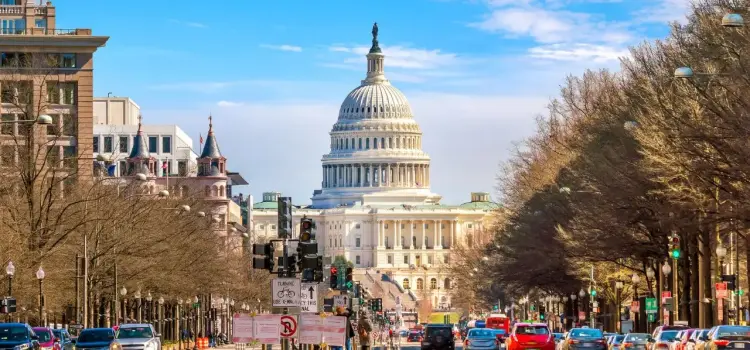 US Capitol building dome rises majestically above Pennsylvania Avenue in Washington DC on sunny day