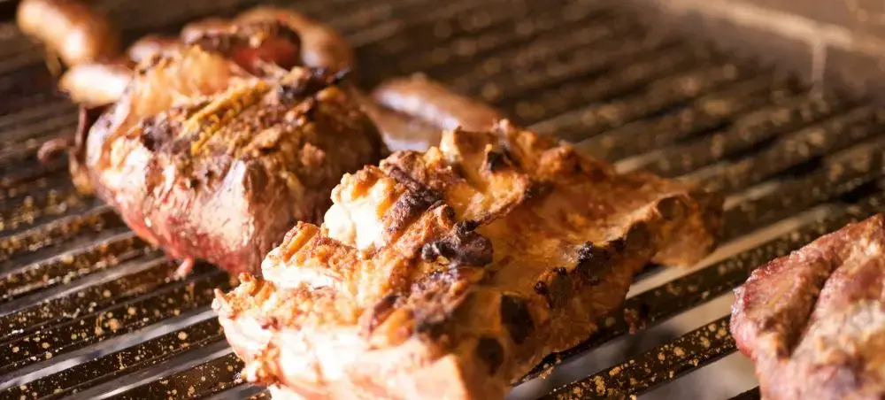 Grilled beef steaks sizzling on barbecue grates showcasing Uruguay's renowned asado culinary tradition