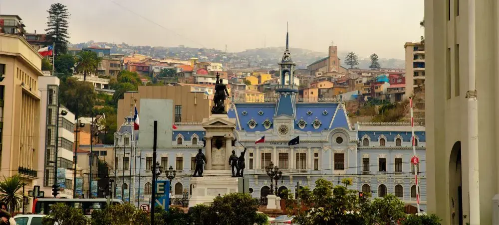 Historic Valparaiso cityscape featuring colorful hillside buildings and ornate naval headquarters architecture