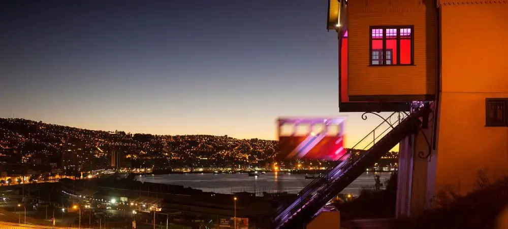 Valparaiso's colorful hillside houses illuminated at twilight overlooking the Pacific Ocean and harbor