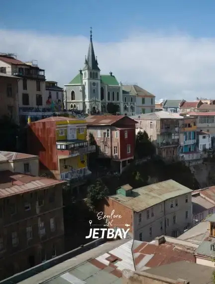Colorful hillside houses and historic church spire showcase Valparaiso's UNESCO World Heritage architecture
