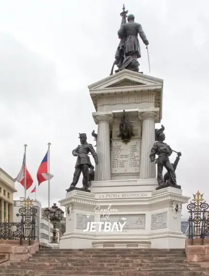 Historic monument in Valparaiso's main plaza featuring bronze soldiers and Chilean flags for luxury travel