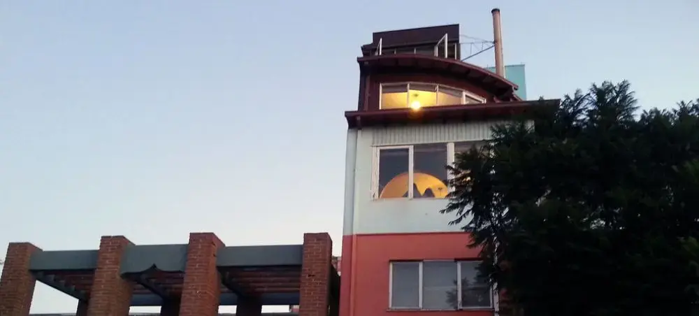 Modern lighthouse tower with illuminated windows at dusk in Valparaiso's historic coastal district