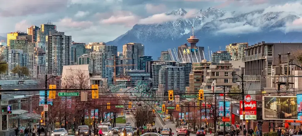 Vancouver downtown skyline with snow-capped North Shore mountains and busy street scene showcasing urban charm