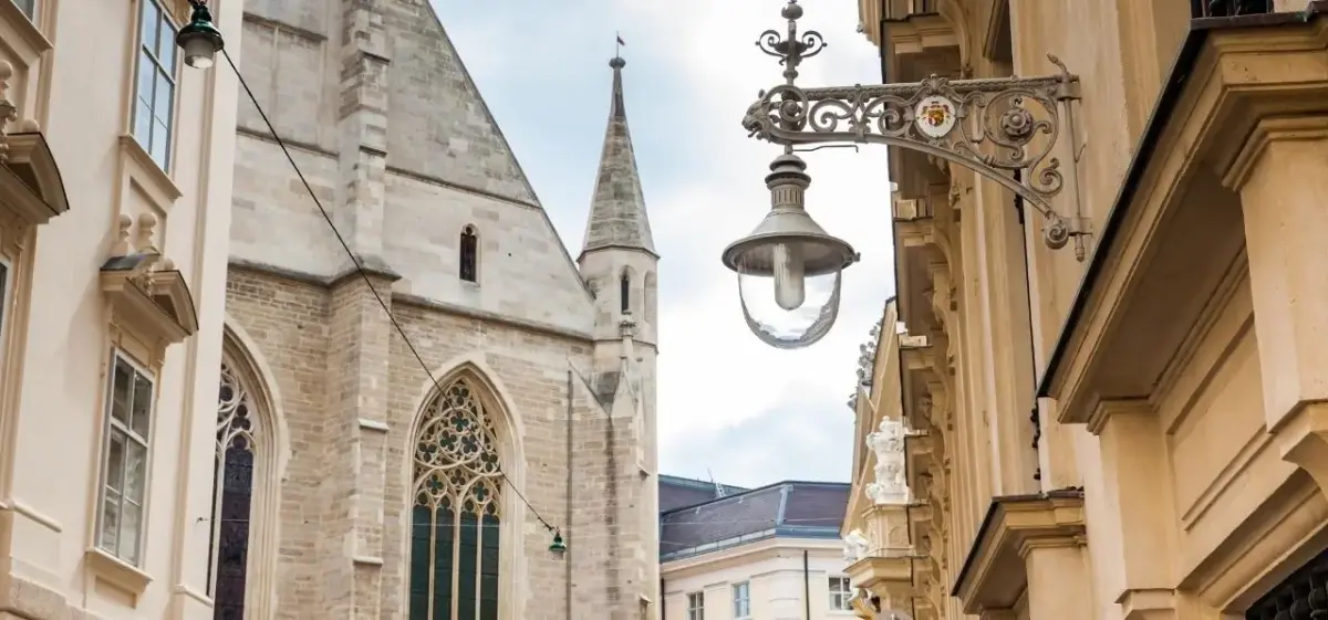 Historic Gothic church spire and ornate street lamp showcase Vienna's architectural heritage and charm