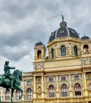 Historic baroque architecture and bronze statue showcase Vienna's imperial grandeur for luxury travelers