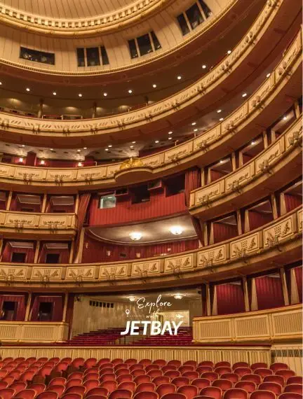 Ornate interior of Vienna State Opera House showcasing golden balconies and red velvet seating