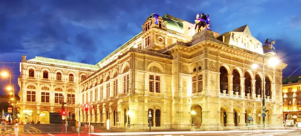 Vienna State Opera House illuminated at twilight showcasing Austria's magnificent baroque architecture