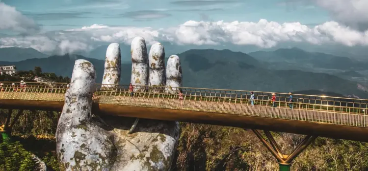 Golden Bridge held by giant stone hands overlooking Vietnam's lush mountains and valleys