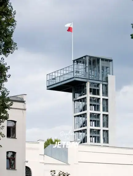 Modern glass observation tower with Polish flag overlooking Warsaw's historic architecture and skyline