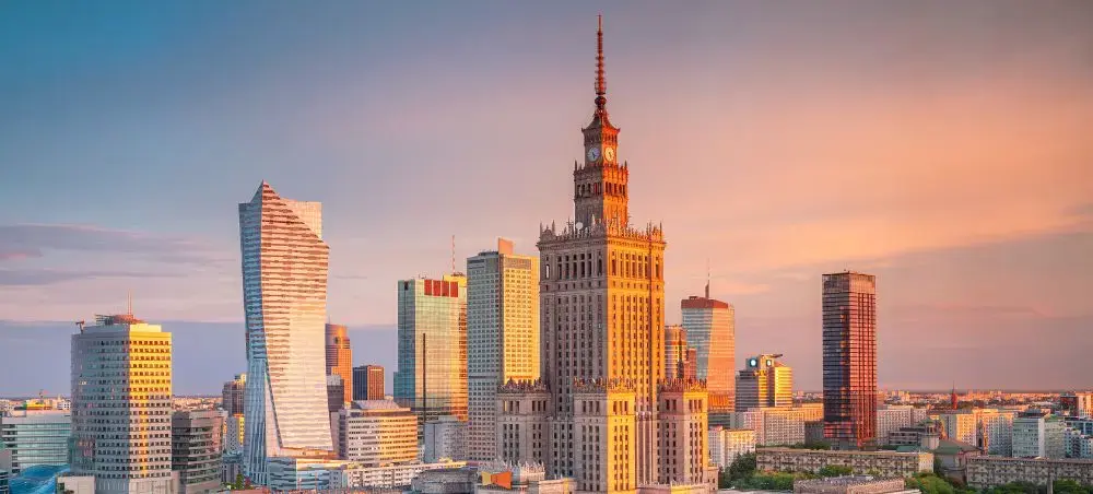 Warsaw skyline at golden hour featuring Palace of Culture and Science amid modern skyscrapers