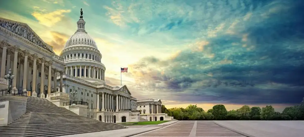 US Capitol Building with iconic dome and American flag under dramatic sunset sky in Washington DC
