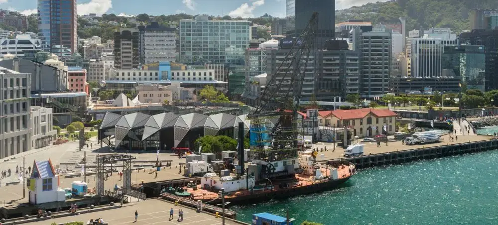 Wellington waterfront showcasing modern harbor buildings and cruise terminal with forested hills backdrop