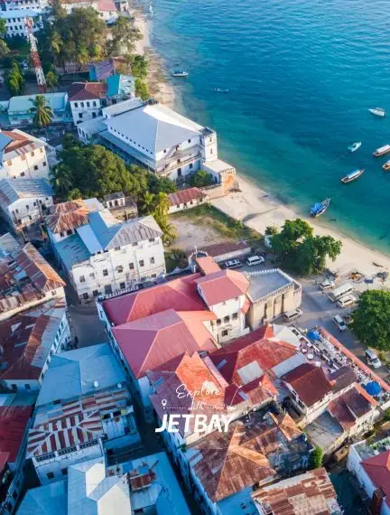 Aerial view of Stone Town Zanzibar's historic waterfront with colorful colonial buildings and turquoise waters