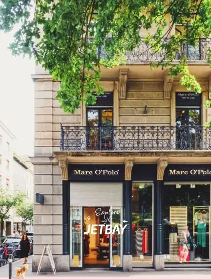 Elegant Zurich shopping street with historic architecture, wrought iron balconies, and luxury boutiques