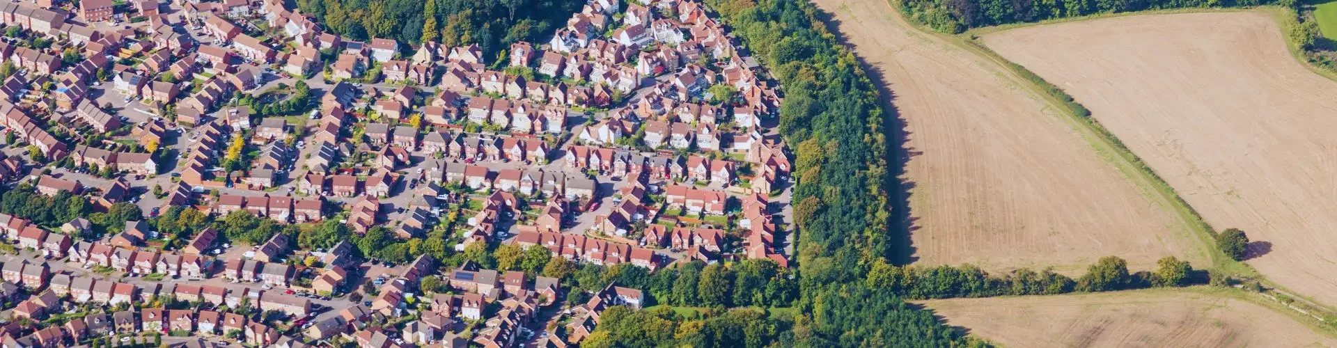 Aerial view of residential neighborhoods and green countryside near London Luton Airport