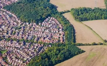 Aerial view of residential neighborhoods and green countryside near London Luton Airport