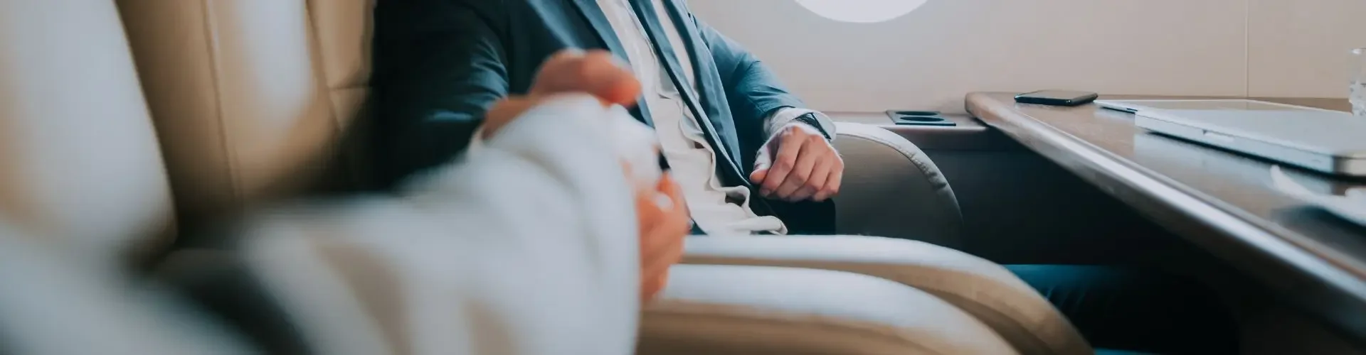 Business executive in tailored suit relaxing in luxury private jet cabin during flight to Davos