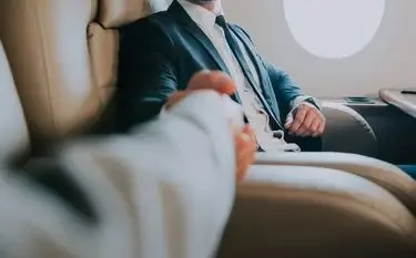 Business executive in tailored suit relaxing in luxury private jet cabin during flight to Davos
