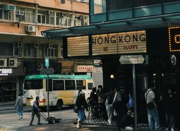 Bustling hong kong street vintage bus neon signs pedestrians crossing urban intersection card txt