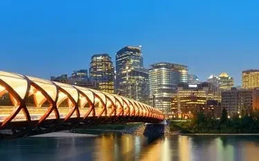Private Jet Charter at Calgary International Airport Calgary skyline dusk illuminated peace bridge downtown towers for private jet charter passengers