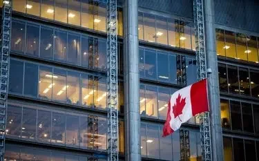 Canadian flag prominently displayed on modern glass office building for luxury business travel