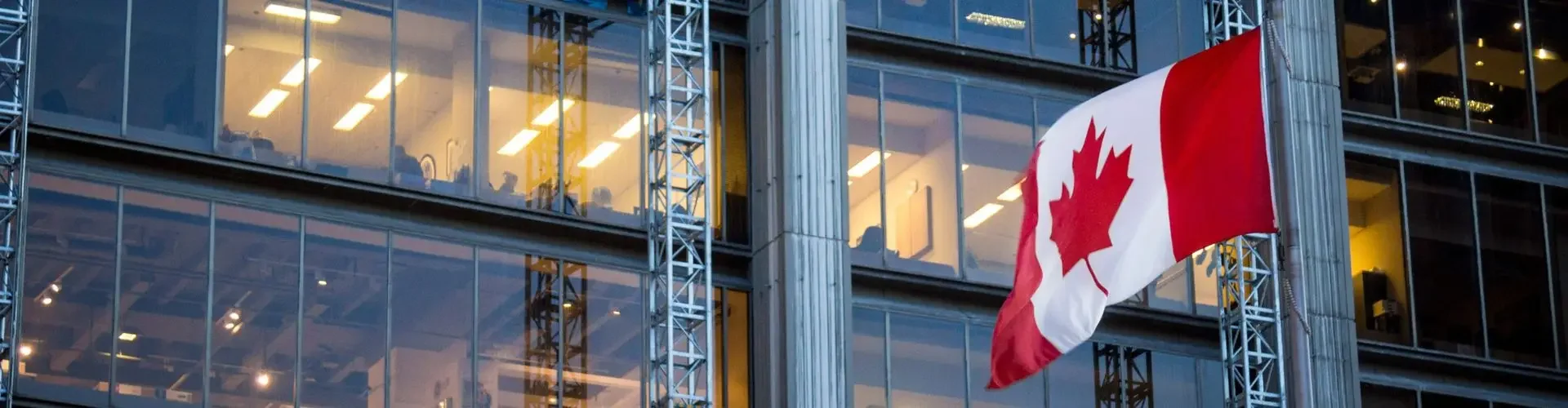 Canadian flag prominently displayed on modern glass office building for luxury business travel