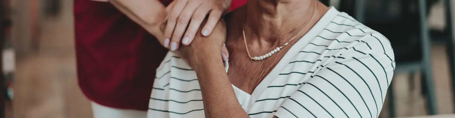 Smiling elderly patient receiving compassionate care from medical professional in comfortable healthcare setting