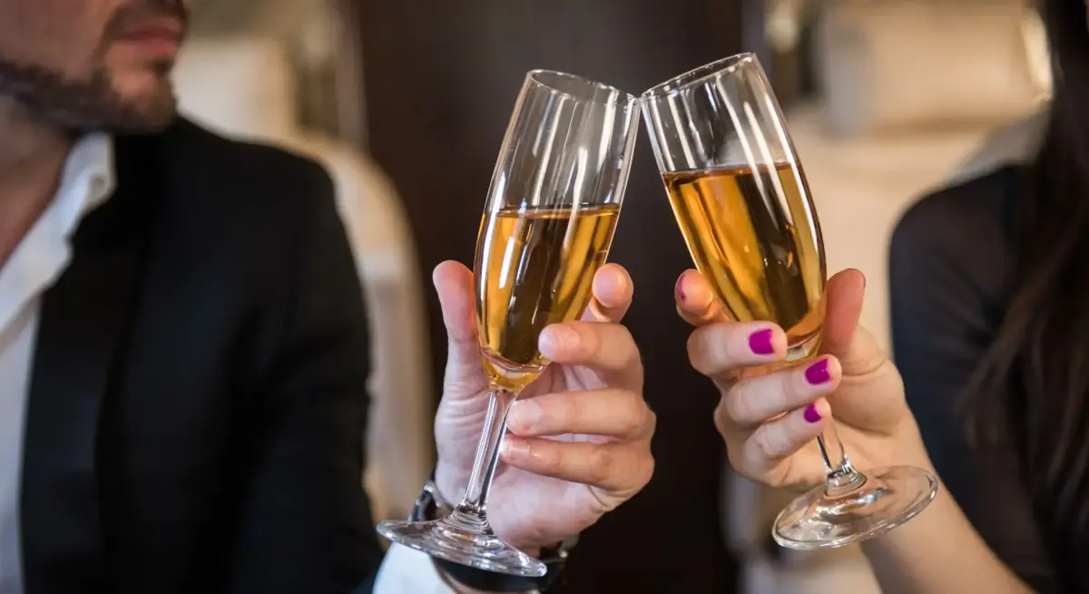 Couple toasting with champagne flutes luxury private jet romantic for a valentines day