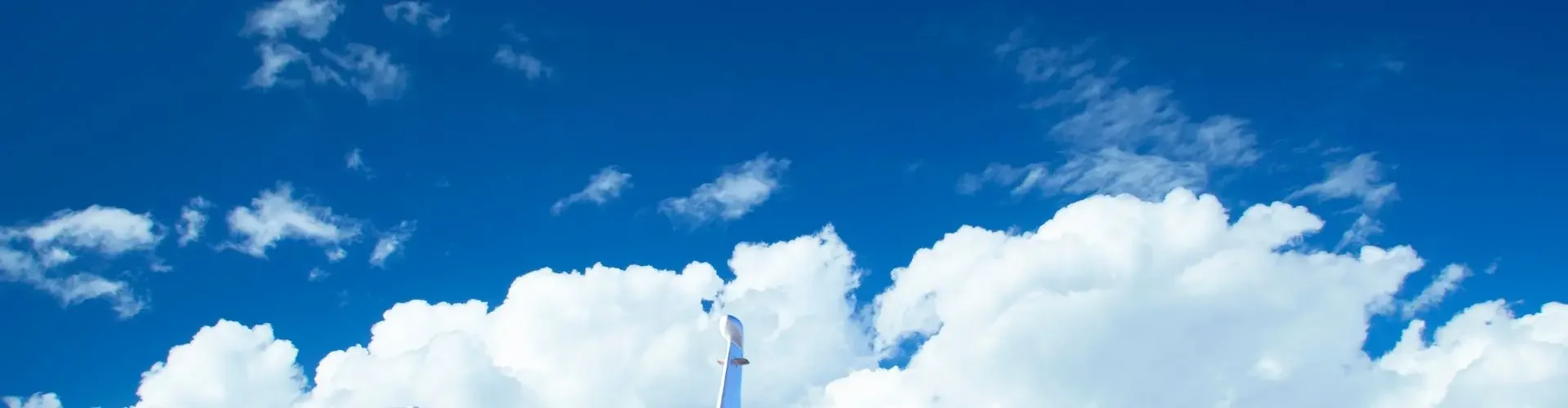 Are Private Jets Faster Than Commercial Planes? White private jet parked on tarmac under dramatic blue sky with puffy white clouds