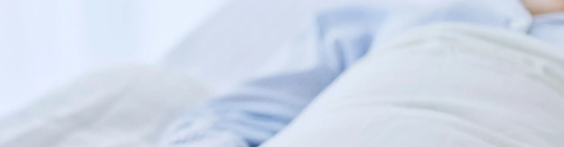 UK Bed-to-Bed Transfer Explained Peaceful hands resting on crisp white bedding symbolizing comfortable bed-to-bed transfer service