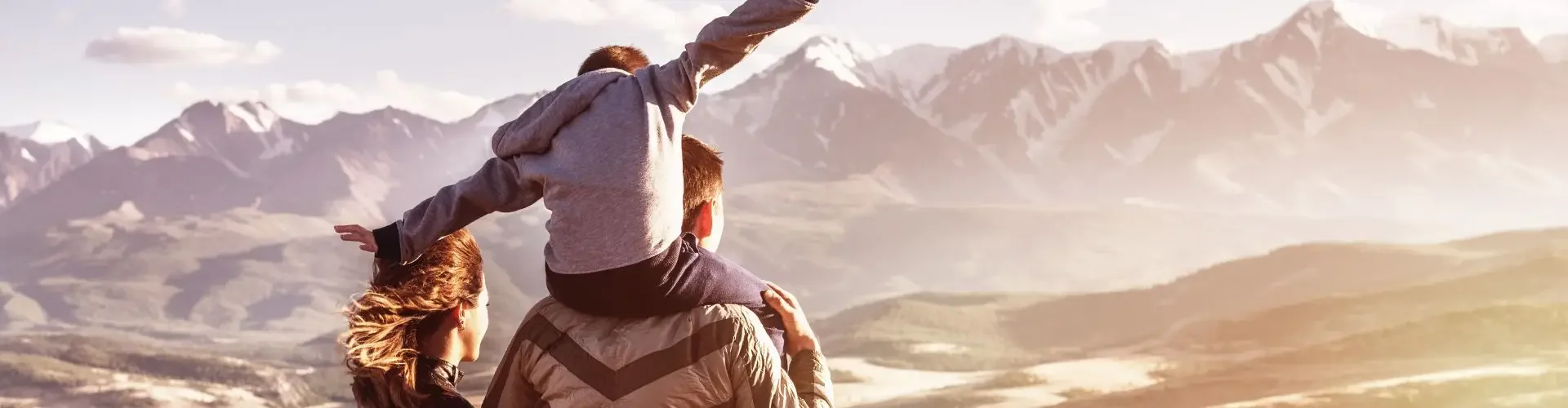 Two travelers celebrating with raised arms overlooking mountain valley, representing shared luxury travel experiences