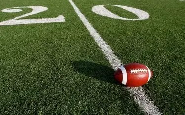 Football positioned on 20-yard line of professional stadium field for Super Bowl 2026 private jet travel
