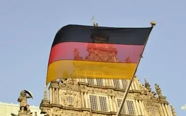 German flag waving above ornate baroque architecture representing luxury travel destinations in Germany