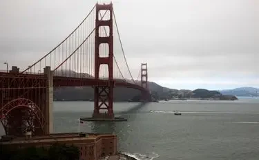 How Much Does a Private Jet Cost in the U.S.? Golden Gate Bridge spanning San Francisco Bay with mountains in background under overcast sky