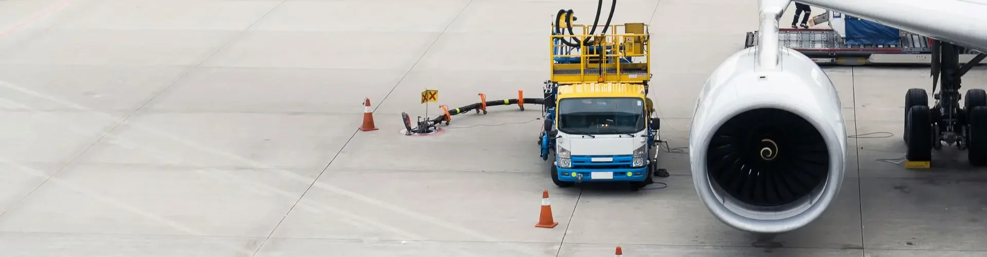 Ground crew refueling private jet wing with sustainable aviation fuel at Singapore airport tarmac