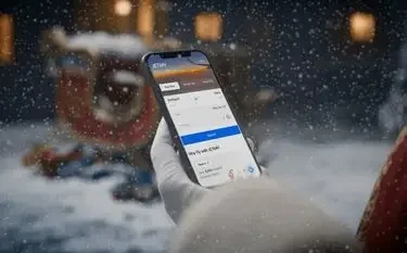 The Gift of Time: Why Flying Private Is the Ultimate Christmas Luxury Hand holding smartphone displaying private jet booking app during snowy Christmas evening outdoors