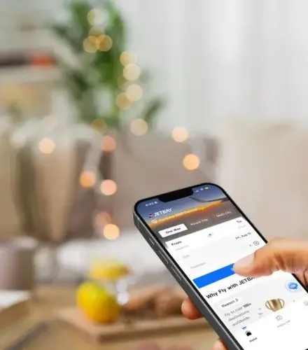 Hand holding smartphone displaying Jetbay booking interface for Lunar New Year travel planning
