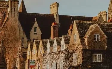 Historic Oxford architecture with golden stone buildings and ivy-covered facades near Oxford Airport