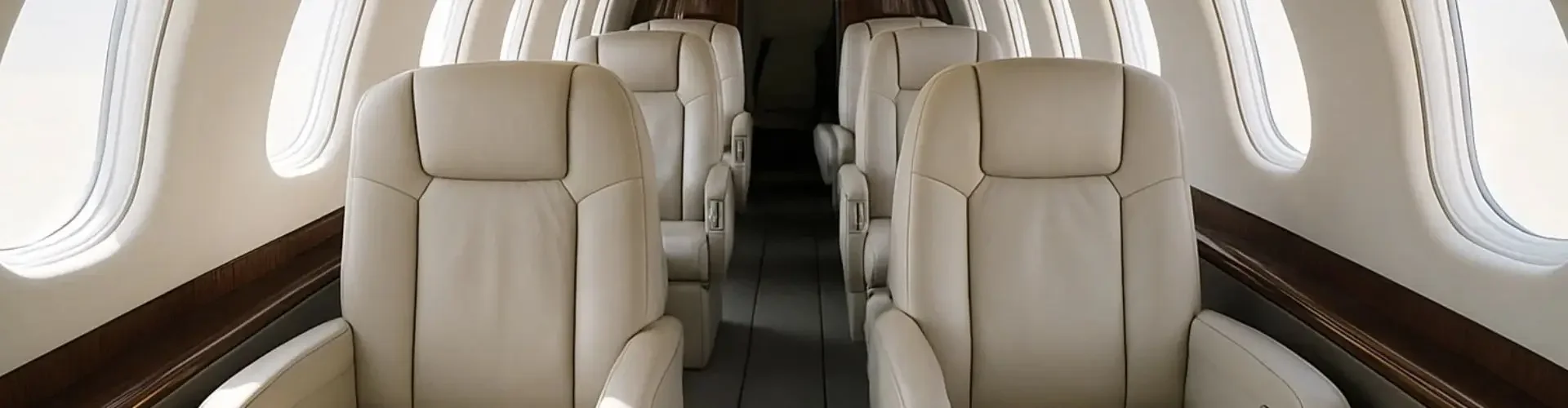 Luxurious private jet cabin interior featuring cream leather seats and panoramic windows for UK charter flights