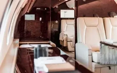 Canada Private Jet vs. First Class: Which One is Better? Luxurious private jet cabin interior with cream leather seats and polished wood finishes for premium travel
